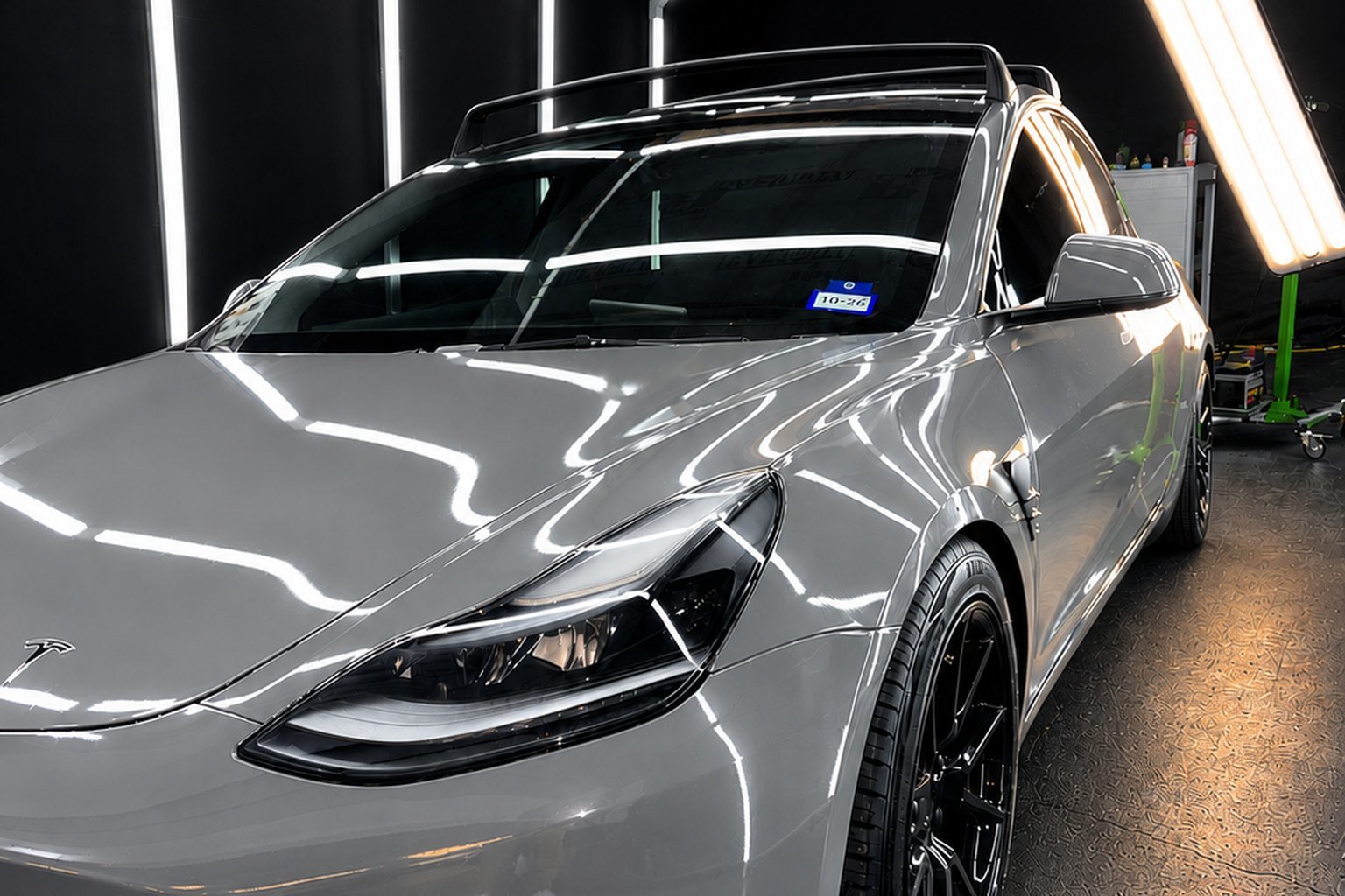Tesla with flawless factory finish under calibrated light lines in the Lone Star PDR studio bay